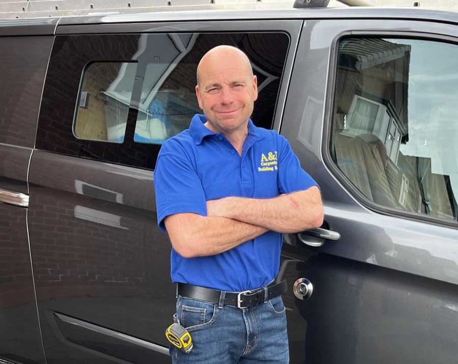 Ade Worton standing beside his work van